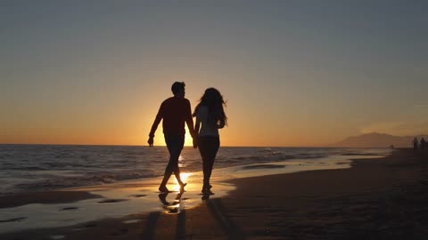 Young couple walking along beach