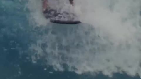 Surfing with his son on his back