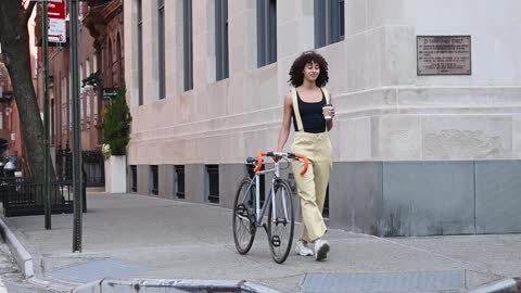 A Woman Walking With Her Bicycle