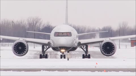 A giant plane takes off and it's snowing