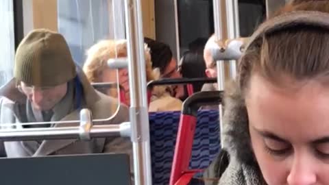 Couple making out on train behind lady with puffy blonde brown hair