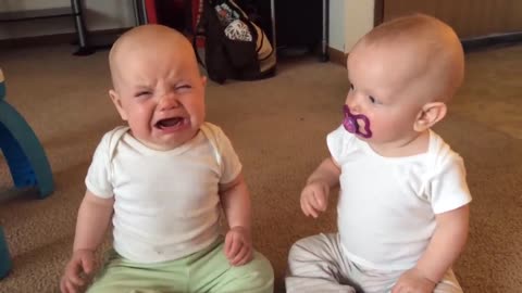 Twin baby girls fight over pacifier