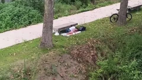 Italian gold medal-winning swimmer Thomas Ceccon sleeping next to park bench.