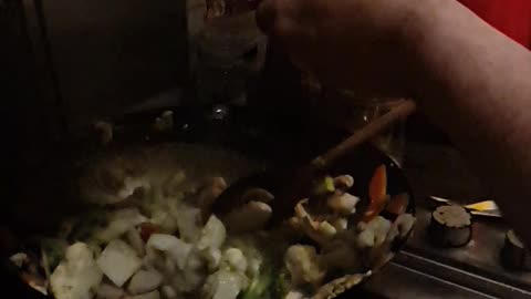 Adding satay sauce to a chicken and vegetable stirfry