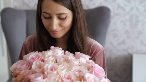 Happy woman with her bouquet of pink flowers