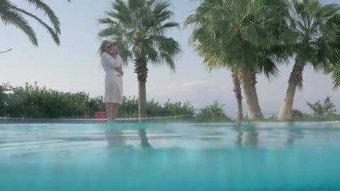 Mother and baby walking by a pool