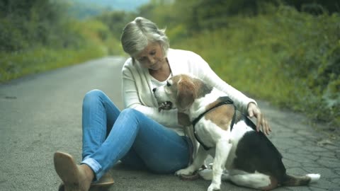 Beautiful senior woman on a walk with her beagle dog,