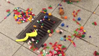 Ripped bag full of candy and one chicken wing on subway station floor