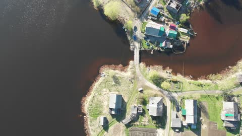 Quadrocopter rises above the village and a beautiful lake.