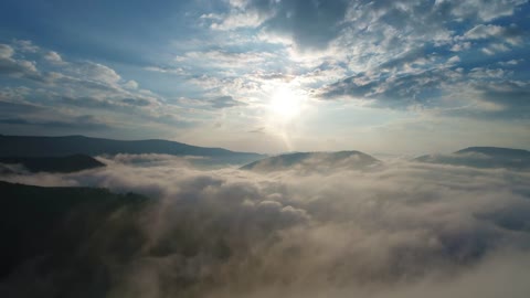 Flying over the clouds on winter mountains