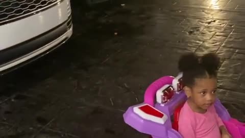 Adorable Toddler wants to park her toy car in her mum's garage