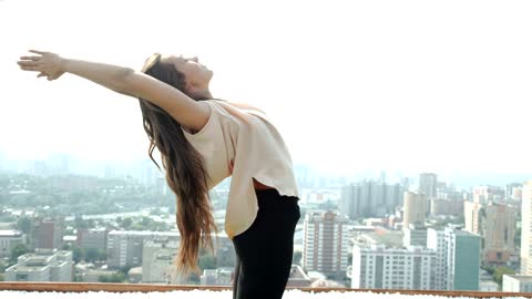 Young woman practicing yoga poses on a rooftop