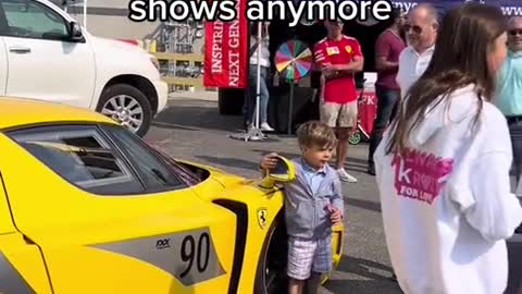 At the auto show, children's cars are very interested in the cars on display.