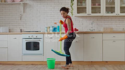 Woman dancing and singing with mop during cleanup stock video