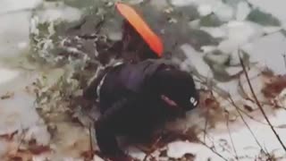 Man sleds down on hills into frozen lake, ice breaks and he falls into lake