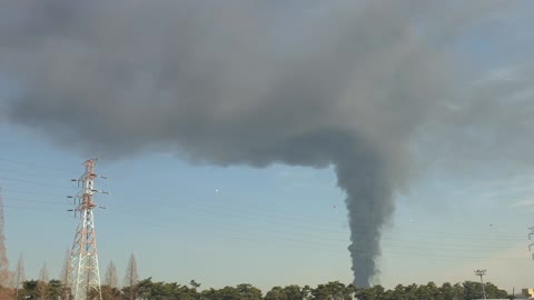 The clear sky and dark clouds coexist due to the fire.