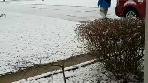 Lousy weather blue jacket guy walking down sidewalk slips on snow