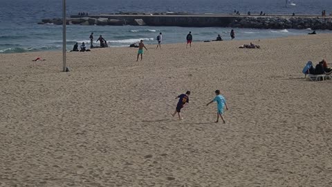 Boys Playing Soccer On A Sea Beach