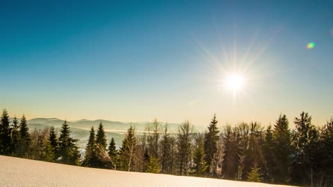 Bright sun in the clear sky in the snowy mountains