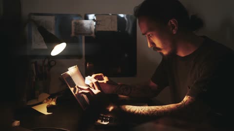 Tattooist Sticking Paper on Laptop to Trace Design