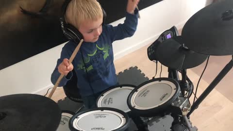 Watch a child playing music on the drums