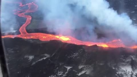 Plane flies over Iceland volcano spewing lava