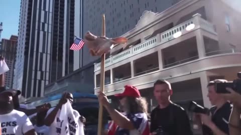 Outside federal court in Miami there’s a guy with the real pigs head on a stick