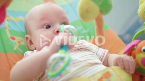 Portrait of newborn kid playing with toy