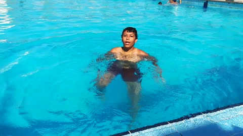 Boy Learns How To Swim In Pool