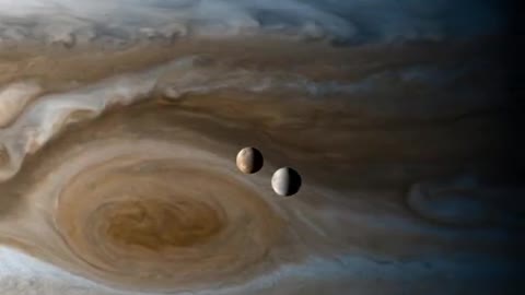 Europa & Io moons orbiting Jupiter, captured by the Cassini space probe