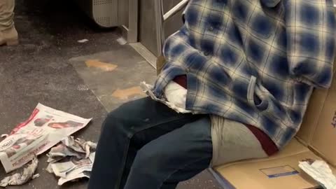 Clothes stuffed with pillows, looks like person sitting on subway, no head