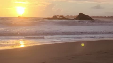 Bright sunset over a shipwreck.