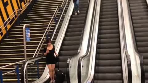 Suitcase Slides Down Escalator