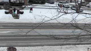 Kids snow sledding on a laundry basket