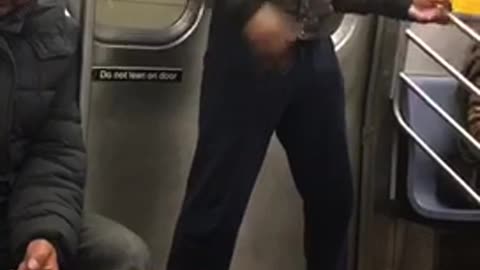 Friyay guy with glasses playing air guitar in subway