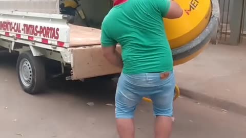 Man Loads Concrete Mixer into a Truck by Himself