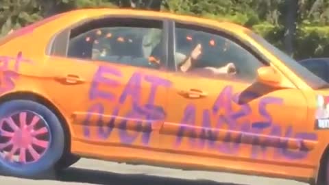 Orange car has purple writing on it