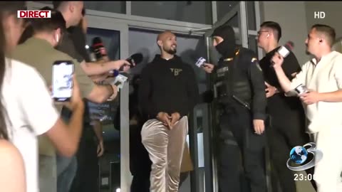 JUST IN: Andrew Tate handcuffed walking to Jail smiling at tens of journalists