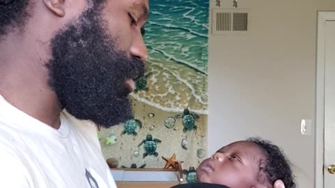 Loving dad sings and dances with his newborn baby