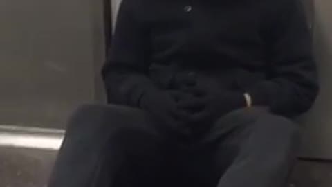 Person dressed as jig saw sitting on subway train floor near door