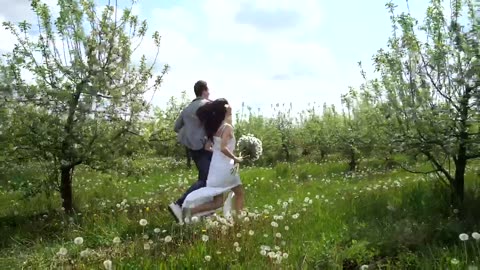 Married couple running through trees