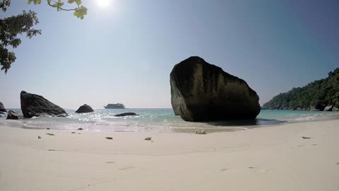 Sunny beach with big rocks