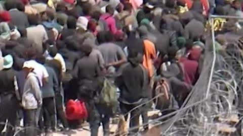 migrants rushing a portion of the US border fence in El Paso, Texas.