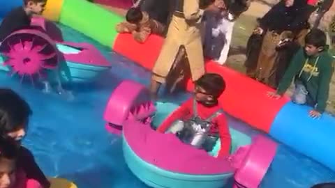 Abdulhadi ride a boat in swimming pool on school party