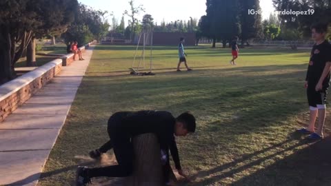 Boy black outfit lands on tree stump on stomach