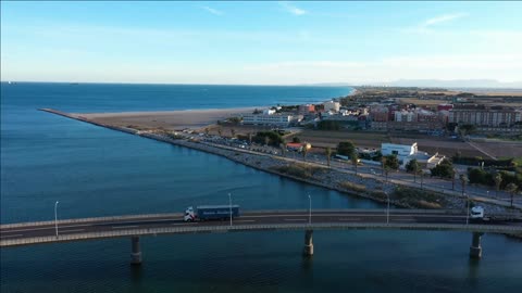 trucks crossing a bridge commercial area valencia pinedo beach aerial shot spain