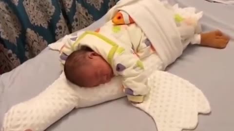 Little cute baby sleeping and a fish is patting him / newborn baby adorable amazing sibling baby