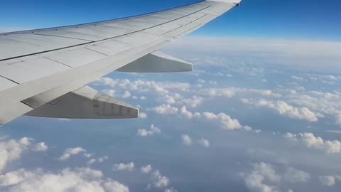 A plane flying in the sky over a cloud