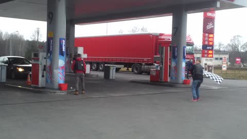 Trolling cars at a gas station with racing flag