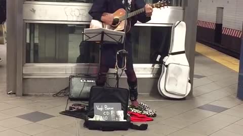 Mezzanine 58 street guy with basket over head playing guitar